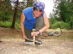 Woman student making fire with a cedar bow drill kit best bow drill woods