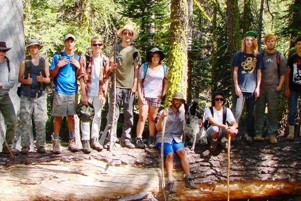 Teens in the forest learning survival skills.