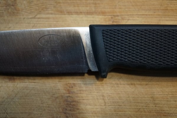 Close-up lose-up of F1 Fallkniven knife where handle meets blade.