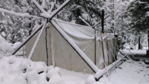 Snowstorm blanketed wall tent during June Edge course.